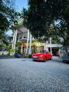 ein rotes Auto, das vor einem Haus parkt in der Unterkunft Thottungal Homestay in Ernakulam