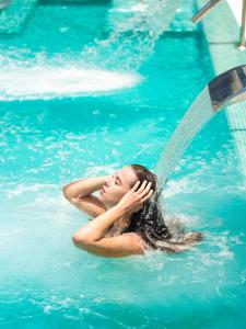 Eine Frau liegt im Wasser in einem Pool. in der Unterkunft MYND Yaiza in Playa Blanca