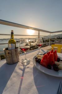 uma mesa com um prato de comida e dois copos de vinho em Mia Hill Suites em Bodrum City