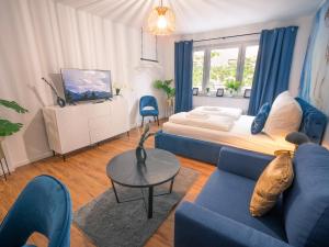 ein Wohnzimmer mit einem blauen Sofa und einem Bett in der Unterkunft Noble Studio - 1 Min to HBF in Mannheim