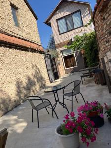 eine Terrasse mit 2 Stühlen, einem Tisch und Blumen in der Unterkunft NewHome in Chişinău