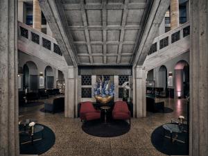 eine Lobby mit roten Stühlen und einem großen Brunnen in der Unterkunft The Wellem, in The Unbound Collection by Hyatt in Düsseldorf