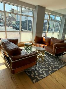 a living room with couches and tables and windows at Citilodge Wakefield Hotel by Roomsbooked in Wakefield