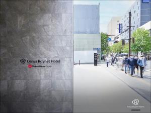 Daiwa Roynet Hotel Sendai Nishiguchi PREMIER في سيندايْ: مجموعة من الناس يسيرون على رصيف مجاور لمبنى