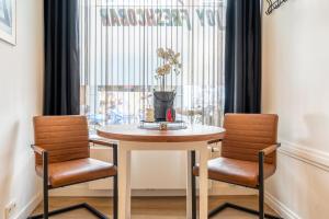 Stylish studio in the heart of Breda city center في بريدا: طاولة طعام مع كرسيين ونافذة