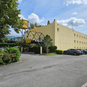 un edificio con un aro de baloncesto en un aparcamiento en Class'Eco Namur, en Namur