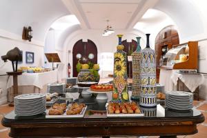 a table with plates and vases on top at Ravello Art Hotel Marmorata in Ravello