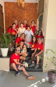 un groupe de personnes posant une photo sur les escaliers dans l'établissement Hue Sweethouse 2 Homestay, à Hue