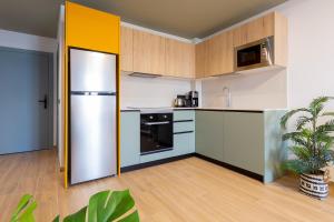 cocina con armarios blancos y nevera en Sholeo Lodges Las Palmas Flats, en Las Palmas de Gran Canaria