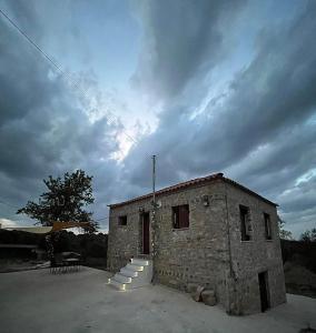 a small stone building with a staircase next to it at Vaki's country house in Pylos