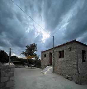 a stone building with a table and a chair next to it at Vaki's country house in Pylos