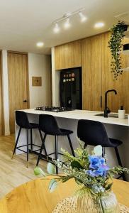 a kitchen with a counter and two chairs and a table at Apartamento Entero en Pinares Pereira in Pereira