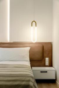 a bedroom with a bed with a light above it at Solridge Aparthotel in Tbilisi City