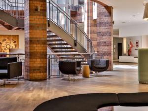 un hall avec des chaises et des escaliers dans un bâtiment dans l'établissement Dorint Hotel Bremen, à Brême