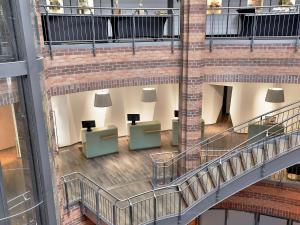 - une vue sur le hall d'un immeuble avec des tables et des chaises dans l'établissement Dorint Hotel Bremen, à Brême