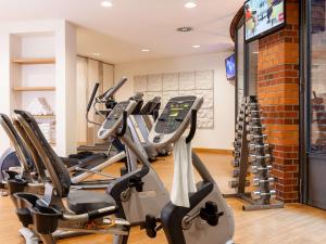 une rangée de tapis de course dans une salle de sport avec des tapis de course dans l'établissement Dorint Hotel Bremen, à Brême