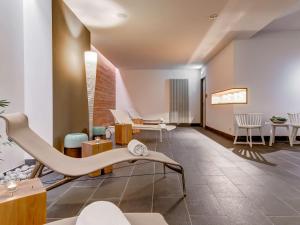 une salle d'attente avec une chaise et des tables dans l'établissement Dorint Hotel Bremen, à Brême