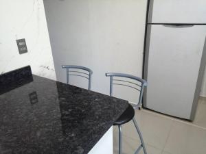 cocina con 2 sillas y encimera con nevera en Departamento Ciudad del Valle, en Tepic