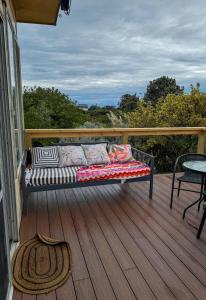 eine Couch auf einer Terrasse mit einem Tisch in der Unterkunft Hennessy Beach House in Port Campbell