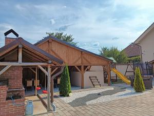 un pavillon en bois avec un toboggan et une aire de jeux dans l'établissement Casa DAnto, à Şelimbăr