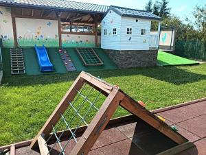 une cour avec une aire de jeux et une maison de jeux dans l'établissement Casa DAnto, à Şelimbăr