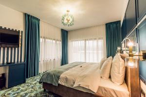 a bedroom with a bed with blue curtains and a chandelier at Villa Galleria in Colibiţa