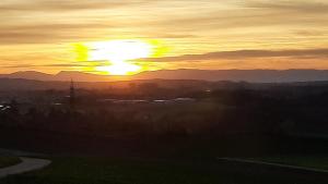 einen Sonnenuntergang mit der Sonne am Himmel in der Unterkunft Chez Astrid in Treyvaux