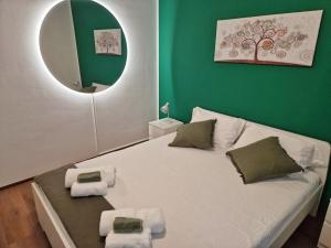 ein Schlafzimmer mit einem großen weißen Bett mit grünen Wänden in der Unterkunft Confortevole appartamento nel cuore di Lugano in Lugano