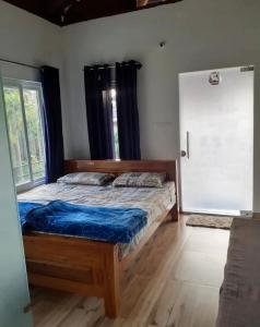 a bedroom with a bed and a window and a door at Saaranga homestay in Avathi