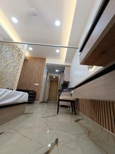 a hotel room hallway with a bed and a bench at Aarohi studio hotels in Noida