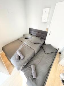 ein großes Bett in einem weißen Zimmer mit zwei Kissen in der Unterkunft Studio Gare de Strasbourg in Straßburg