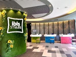 ein Restaurant mit einer grünen Wand mit Sonnenblumen in der Unterkunft ibis Styles Tokyo Bay in Urayasu