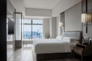 Un pat sau paturi într-o cameră la Chongqing Marriott Hotel