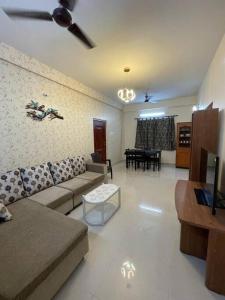 a living room with a couch and a table at V4 Stay - Luxury 1 BHK AC Suite sleeps 5 guests in Coimbatore