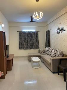 a living room with a couch and a table at V4 Stay - Luxury 1 BHK AC Suite sleeps 5 guests in Coimbatore