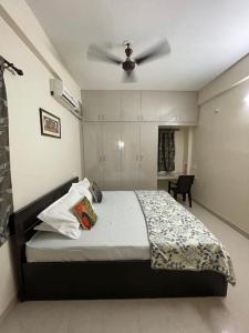 a bedroom with a bed with a ceiling fan at V4 Stay - Luxury 1 BHK AC Suite sleeps 5 guests in Coimbatore