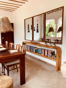 ein Wohnzimmer mit einem Tisch und einem Bücherregal mit Büchern in der Unterkunft Pucci House Watamu in Watamu