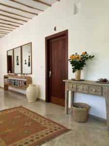 Zimmer mit Holztür und einem Tisch mit Blumen in der Unterkunft Pucci House Watamu in Watamu