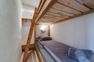 een stapelbed in een kleine kamer met een ladder bij Appartement chaleureux au Chalet Barme de l'Ours 2 in Val dʼIsère