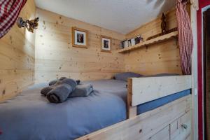 een slaapkamer met een bed in een blokhut bij Appartement chaleureux au Chalet Barme de l'Ours 2 in Val dʼIsère