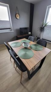 una mesa de madera con cuatro placas verdes. en Apartament SOLO, en Pruszcz Gdański