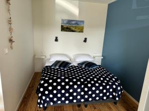 1 dormitorio con cama de lunares blanca y negra en Studio appartement 1nul9Noord, en Renesse