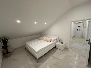 um quarto branco com uma cama e uma escada em Apartments Mio em Crikvenica