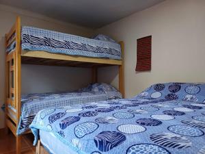 - une chambre avec des lits superposés et une couette bleue dans l'établissement La Maison de Frida, à Cusco