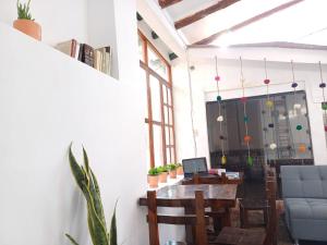 - une salle à manger avec une table et un ordinateur portable dans l'établissement La Maison de Frida, à Cusco