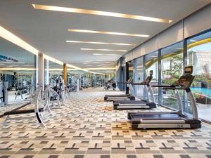 un gimnasio con cintas de correr y máquinas en un edificio en Novotel Lampung en Bandar Lampung