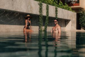 a man and a woman sitting in the water at M Boutique Hotel - Designed for Adults in Paphos City