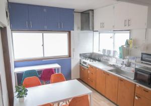 een keuken met blauwe kasten en oranje stoelen bij Kairakuen Guesthouse - Vacation STAY 26929v in Mito