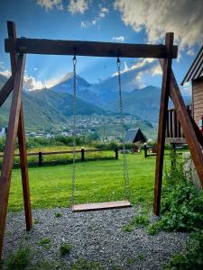 eine Schaukel auf einem Feld mit Bergen im Hintergrund in der Unterkunft Hillside Kazbegi in Kazbegi