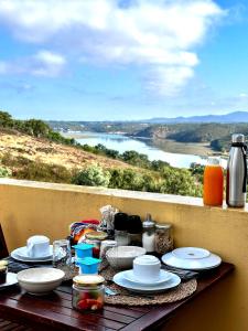 un tavolo con piatti e tazze e una vista sul fiume di Monte Do Zambujeiro a Vila Nova de Milfontes